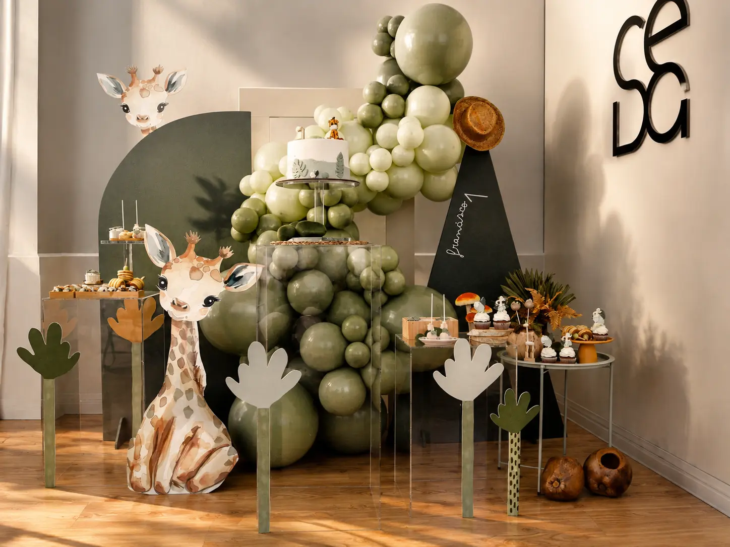 Decoração de aniversário com tema safari, balões verdes e mesa de doces